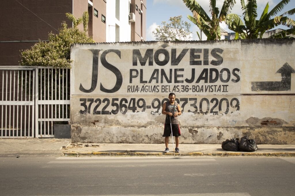 Luciano tentando atravessar uma rua na faixa de pedestres que está praticamente apagada